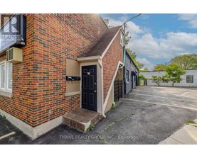 A brick building with a black door and a sign that says REALTOR.