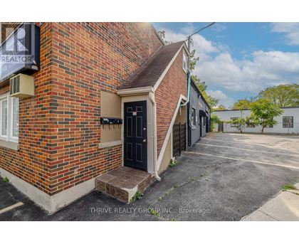 A brick building with a black door and a sign that says REALTOR.