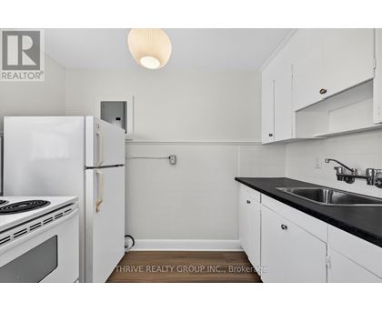 A small kitchen with white cabinets and a black countertop.