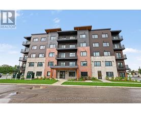 A multi-story apartment building with a parking lot in front.