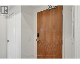 A brown door with a silver handle and lock.
