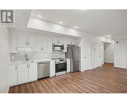 A modern kitchen with white cabinets and stainless steel appliances.