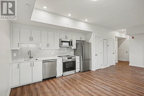 A modern kitchen with white cabinets and stainless steel appliances.