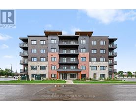 A large apartment building with multiple balconies and a clear sky in the background.