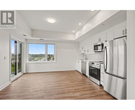 A modern kitchen with white appliances and wooden floors.