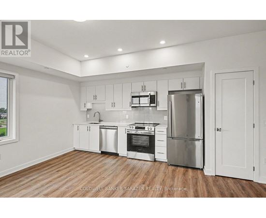 A modern kitchen with white cabinets and stainless steel appliances.