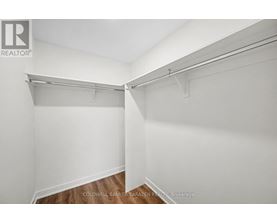 A white wall with a shelf and a brokerage sign.
