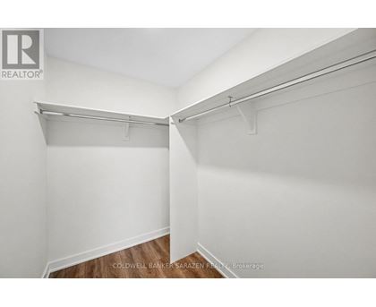 A white wall with a shelf and a brokerage sign.