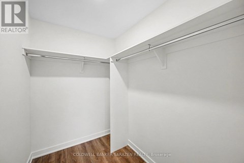 A white wall with a shelf and a brokerage sign.