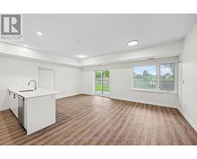 A spacious room with a kitchenette and sliding glass doors leading to a patio.