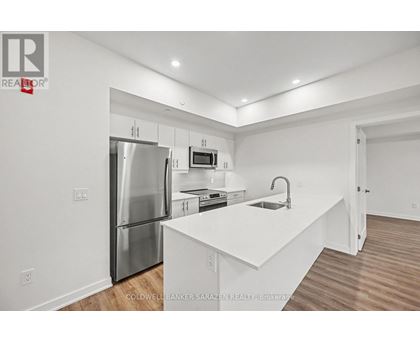 A modern kitchen with white cabinets and stainless steel appliances.