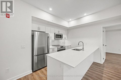 A modern kitchen with white cabinets and stainless steel appliances.