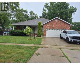 A white truck is parked in front of a brick house.