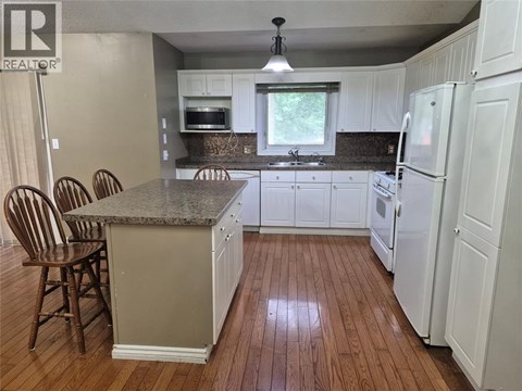 A kitchen with white cabinets and a granite countertop.