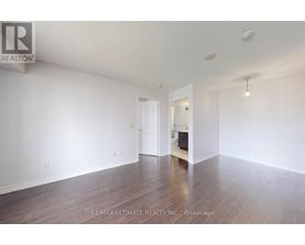 A spacious room with wooden floors and white walls, ready for staging.