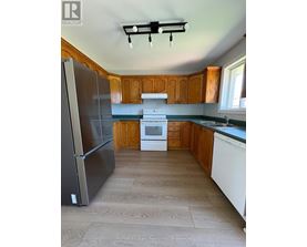 A kitchen with a refrigerator, oven, and microwave.