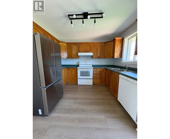A kitchen with a refrigerator, oven, and microwave.