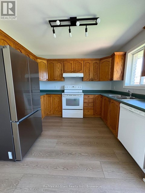 A kitchen with a refrigerator, oven, and microwave.
