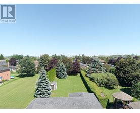 A bird's eye view of a residential area with houses, trees, and a gazebo.