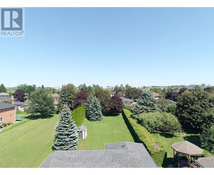 A bird's eye view of a residential area with houses, trees, and a gazebo.