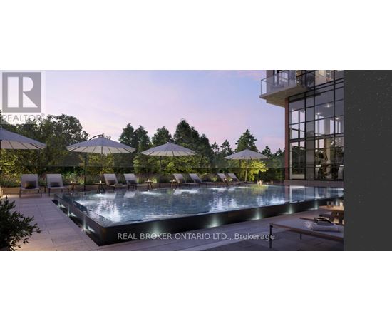 A large outdoor swimming pool surrounded by lounge chairs and umbrellas.