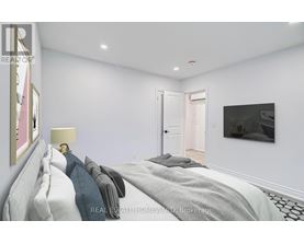 A bedroom with a bed, lamp, and painting on the wall.