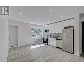 A modern kitchen with white cabinets and a stainless steel refrigerator.