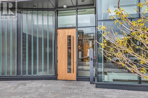 A glass door with a wooden frame is the entrance to a building.