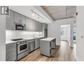 A modern kitchen with stainless steel appliances and white cabinetry.