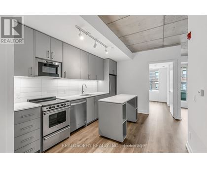 A modern kitchen with stainless steel appliances and white cabinetry.
