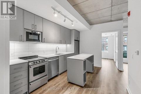 A modern kitchen with stainless steel appliances and white cabinetry.