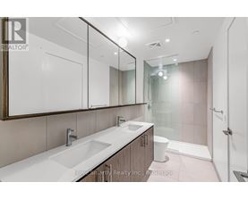 A bathroom with a sink, mirror, toilet, and shower.
