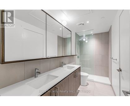 A bathroom with a sink, mirror, toilet, and shower.