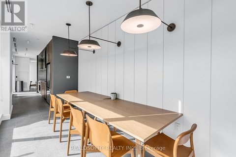 A modern dining room with a long table and chairs.