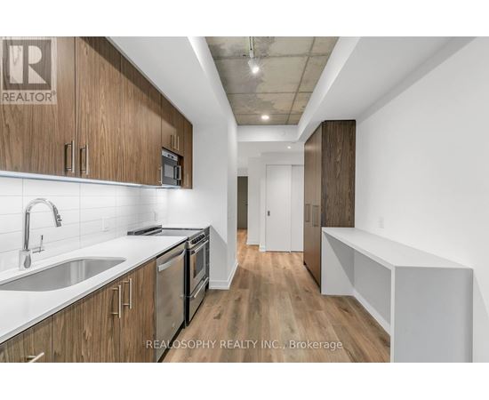 A kitchen with wooden cabinets and stainless steel appliances.