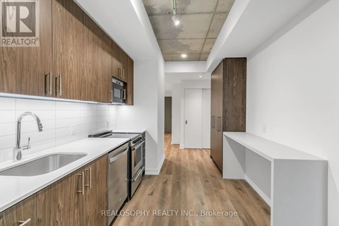 A kitchen with wooden cabinets and stainless steel appliances.