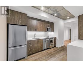 A modern kitchen with wooden cabinets and stainless steel appliances.