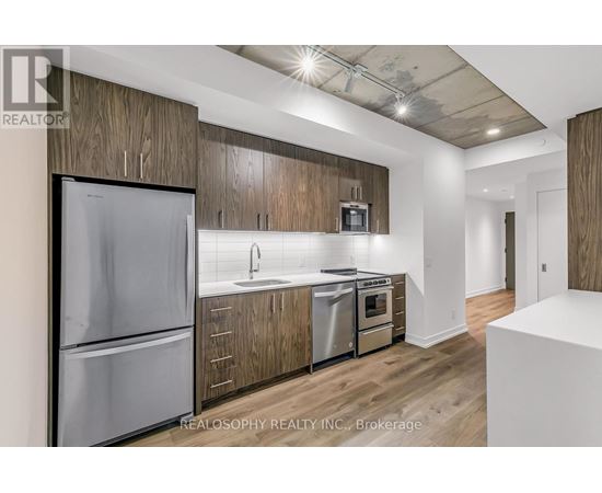 A modern kitchen with wooden cabinets and stainless steel appliances.
