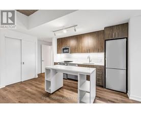A kitchen with a white table and a refrigerator.