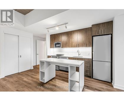 A kitchen with a white table and a refrigerator.