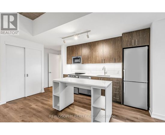 A kitchen with a white table and a refrigerator.