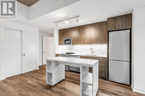 A kitchen with a white table and a refrigerator.