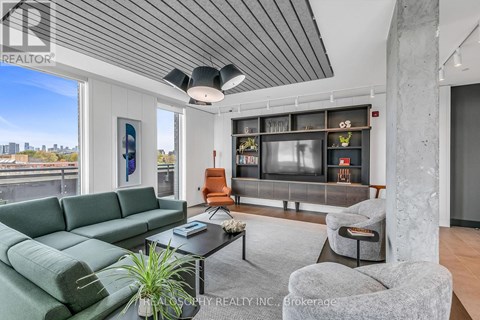 A living room with a green sofa and a grey armchair.