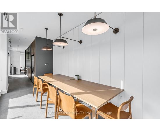 A modern dining room with a long table and chairs.