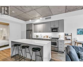 A modern kitchen with a white countertop and stainless steel appliances.