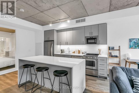 A modern kitchen with a white countertop and stainless steel appliances.