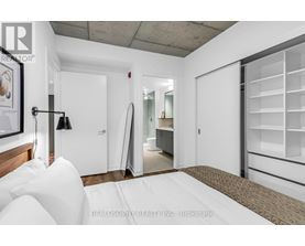 A bedroom with a bed, a lamp, and a wardrobe.