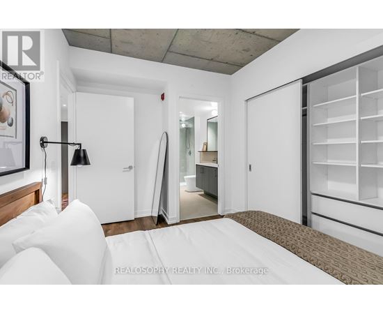 A bedroom with a bed, a lamp, and a wardrobe.