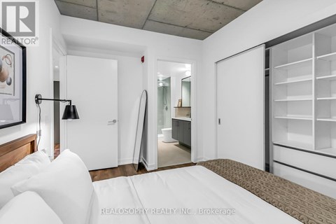 A bedroom with a bed, a lamp, and a wardrobe.