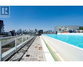 A pool area with a clear blue sky above and buildings in the distance.